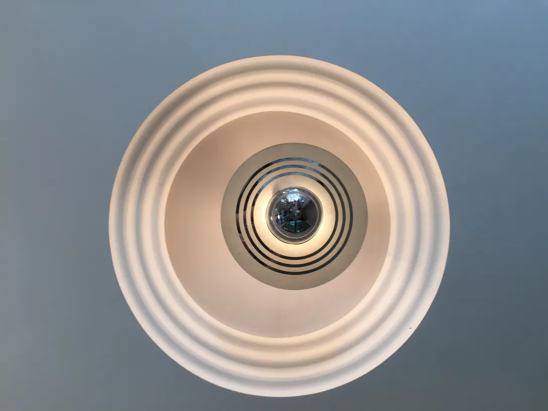 Antike Hängelampe mit kreisförmigem Design und sanftem Licht.