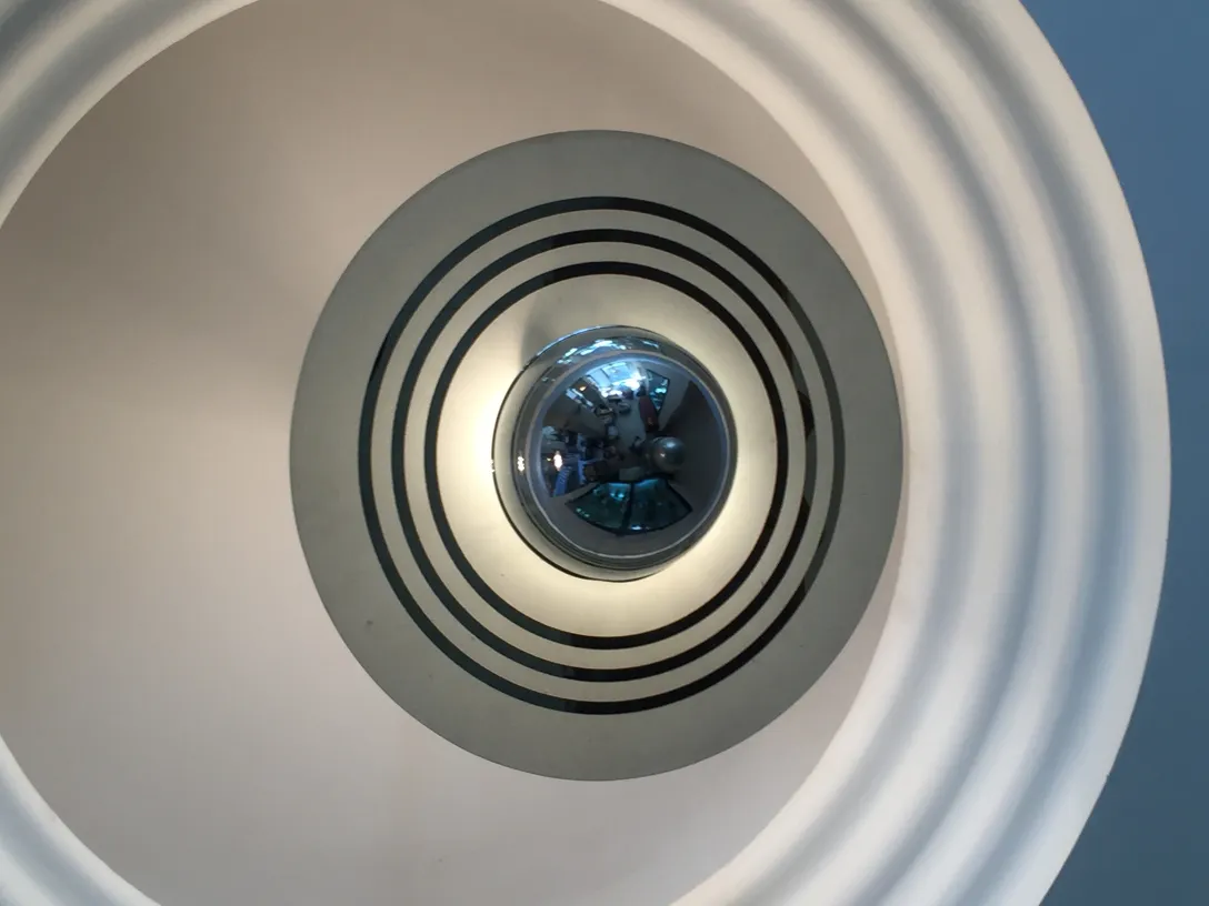 Antike Hängelampe mit rundem Design und modernen Oberflächen in einem zeitgenössischen Umfeld.