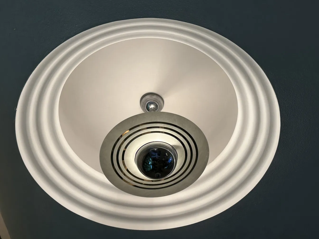 Antike Hängelampe mit gestreiften Designdetails, die den Raum beleuchtet.