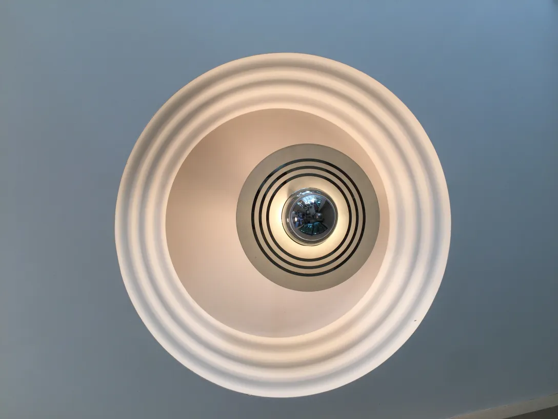 Antique hanging lamp with modern design, circular shape and center details, illuminating a space.