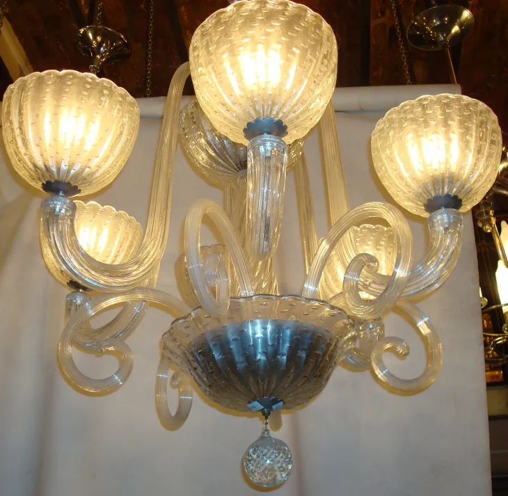 antiga lâmpada de teto com braços curvados e iluminação quente