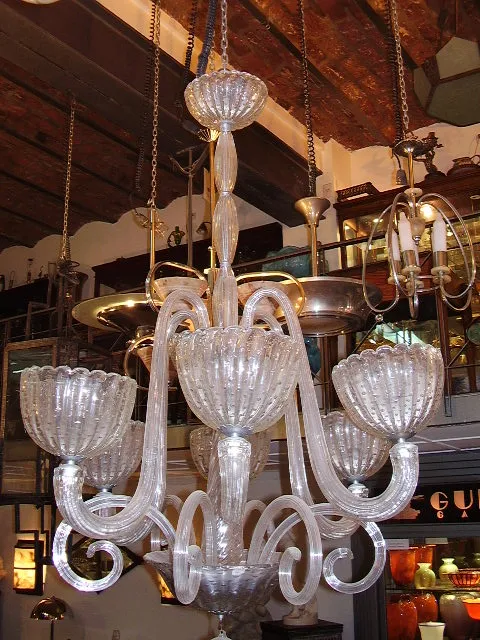 Lampada a sospensione antica in vetro con più braccia e dettagli.