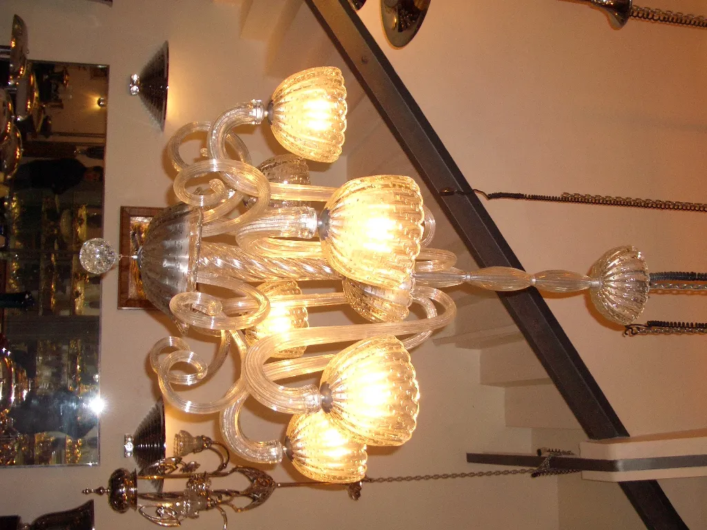 Lámpara de techo antigua de cristal con luces cálidas, elegante diseño en un ambiente acogedor.