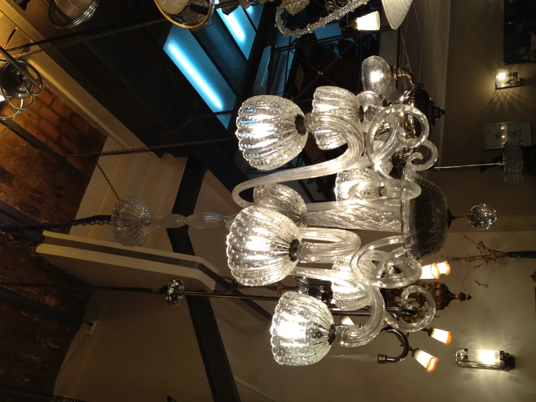 Lampada a sospensione antica con cristallo chiaro e design elegante, ambientata in un contesto con altre lampade.