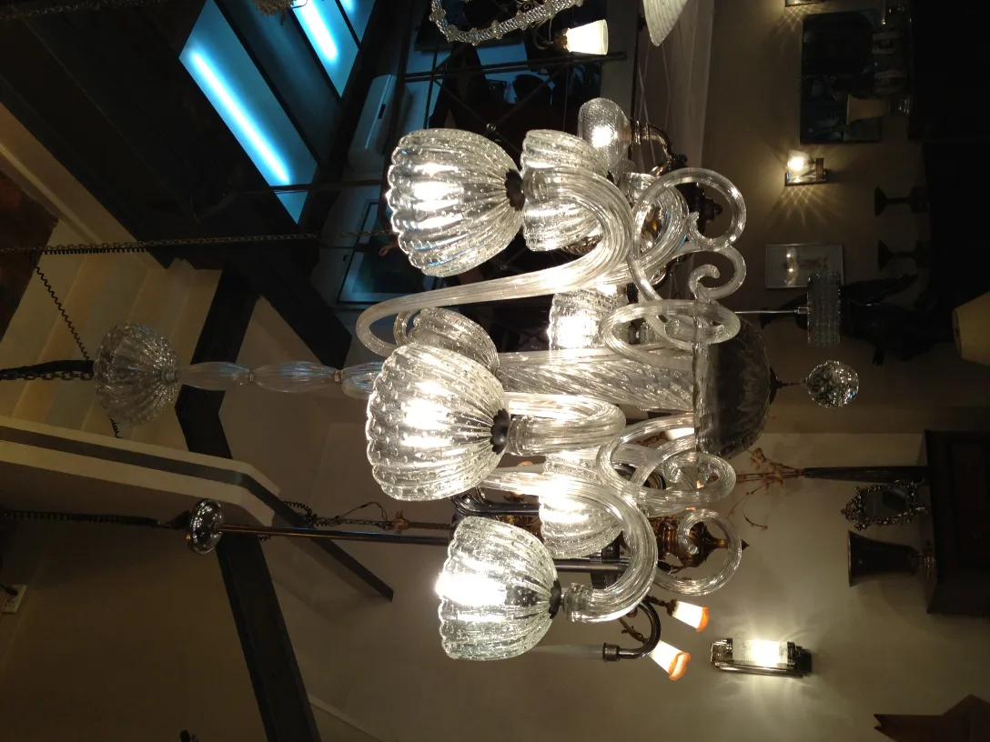 Lampada a sospensione antica in vetro con bracci decorativi.