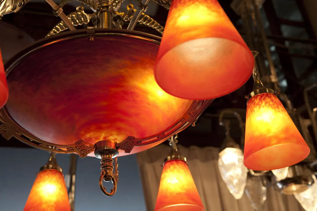 Lustre ancien avec abat-jour orange, ambiance chaleureuse.