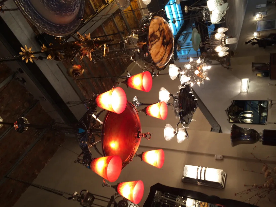 Lámpara de techo antigua con luces rojas brillantes en un ambiente elegante.