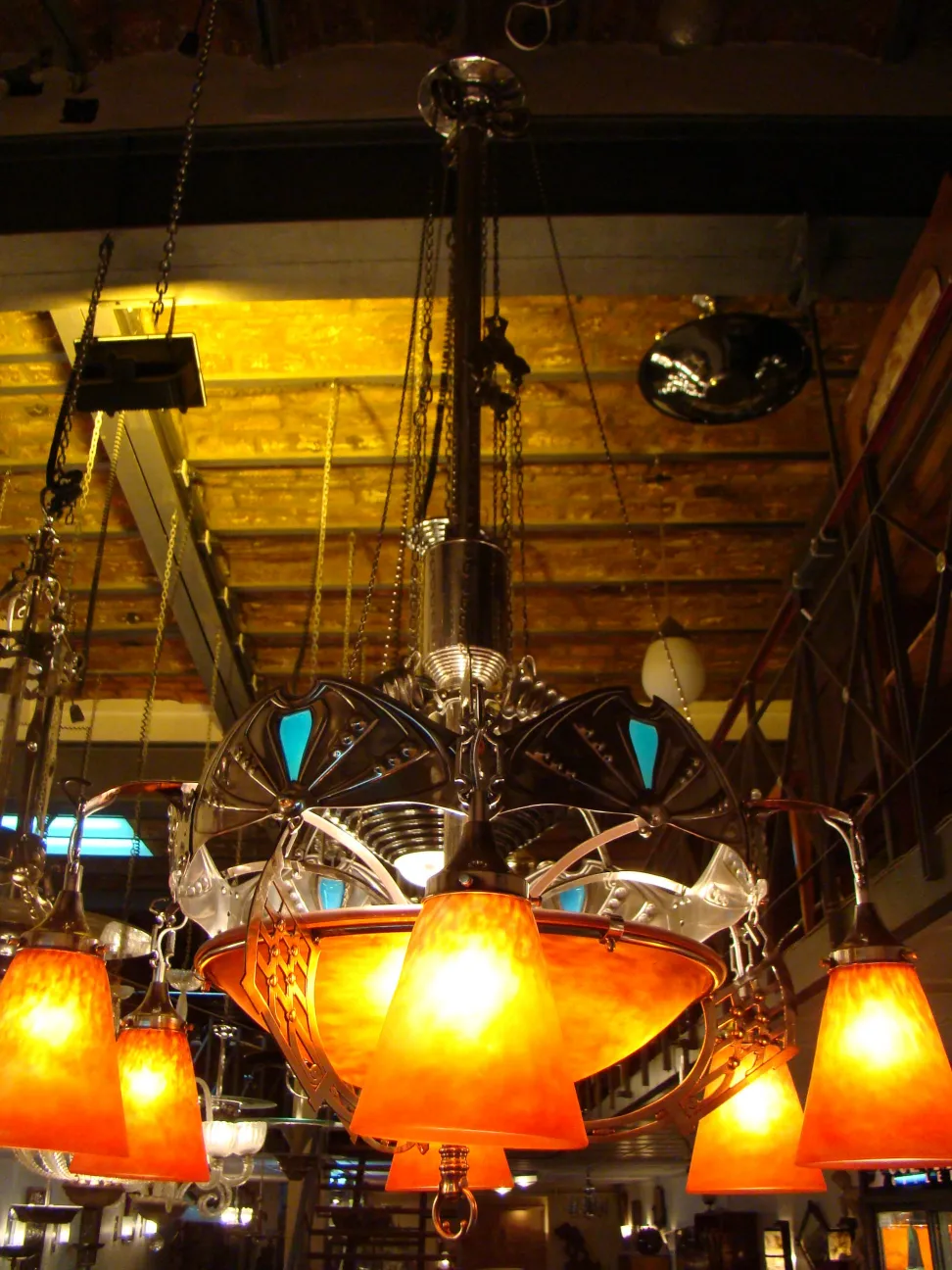 lampada a sospensione antica di Charles Schneider con paralumi arancioni in un ambiente illuminato e elegante