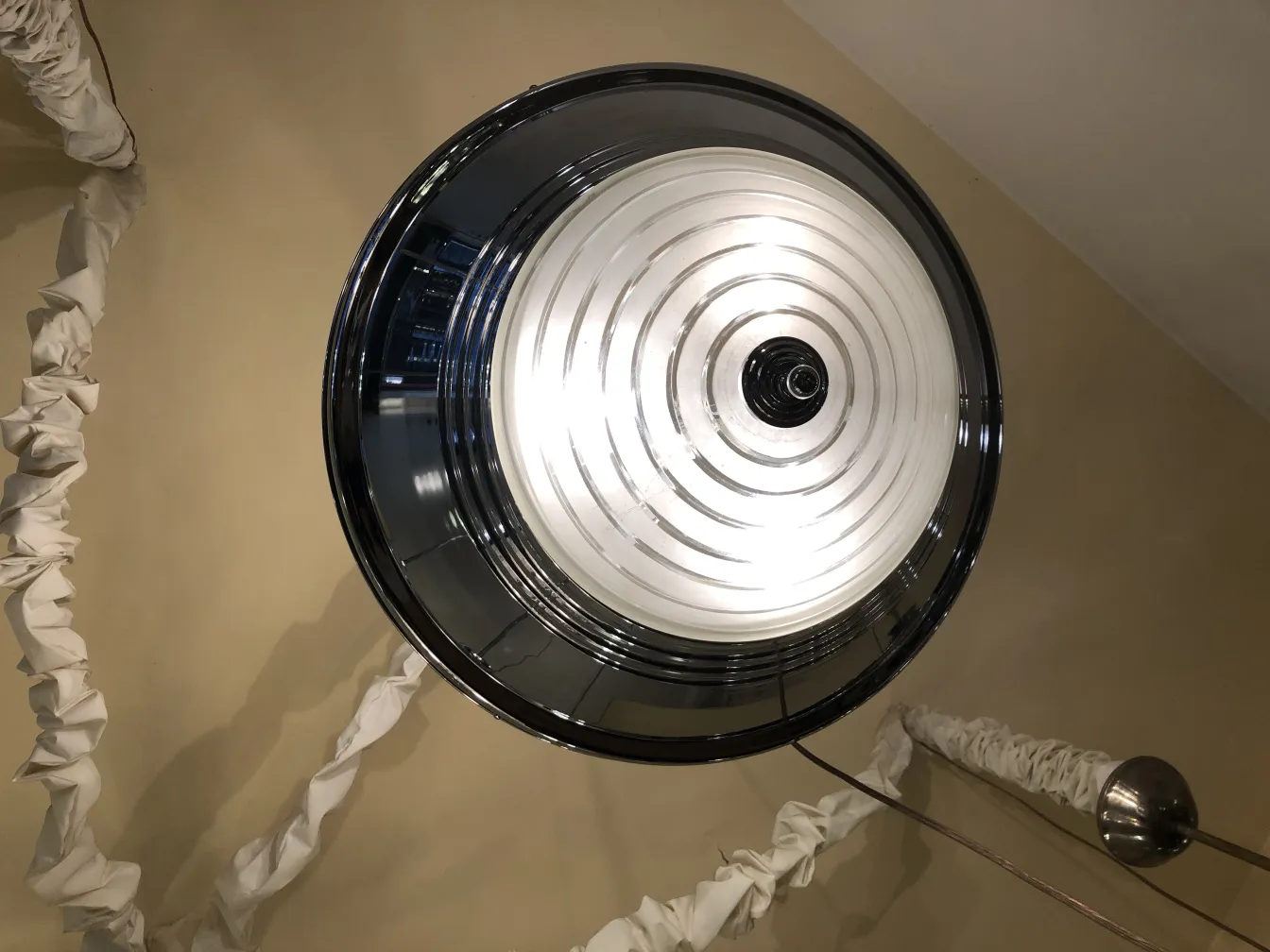 Lustre ancien avec détails uniques et lumières brillantes, installé dans une pièce élégante.