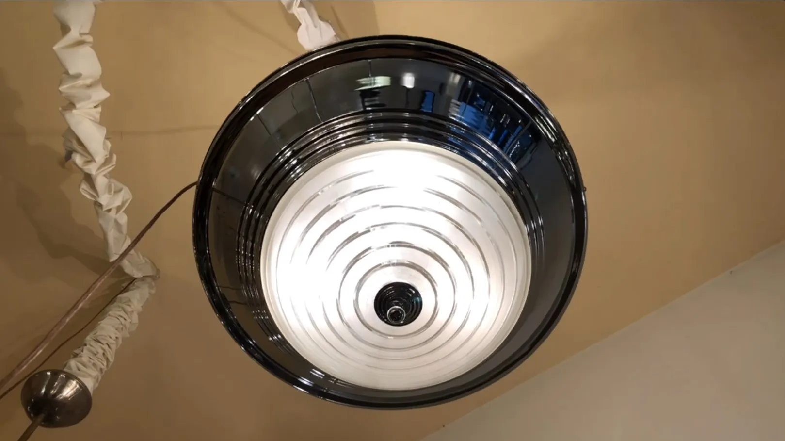 Lampada a sospensione antica con motivo circolare, atmosfera calda.