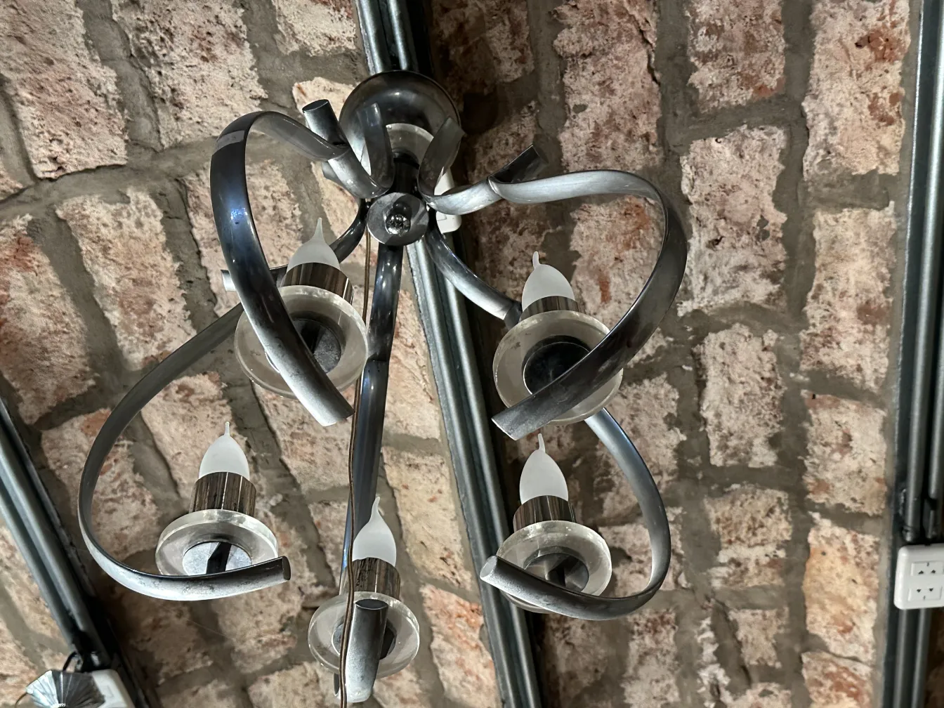 Lampada a sospensione antica con dettagli unici in metallo e vetro, ambiente rustico.