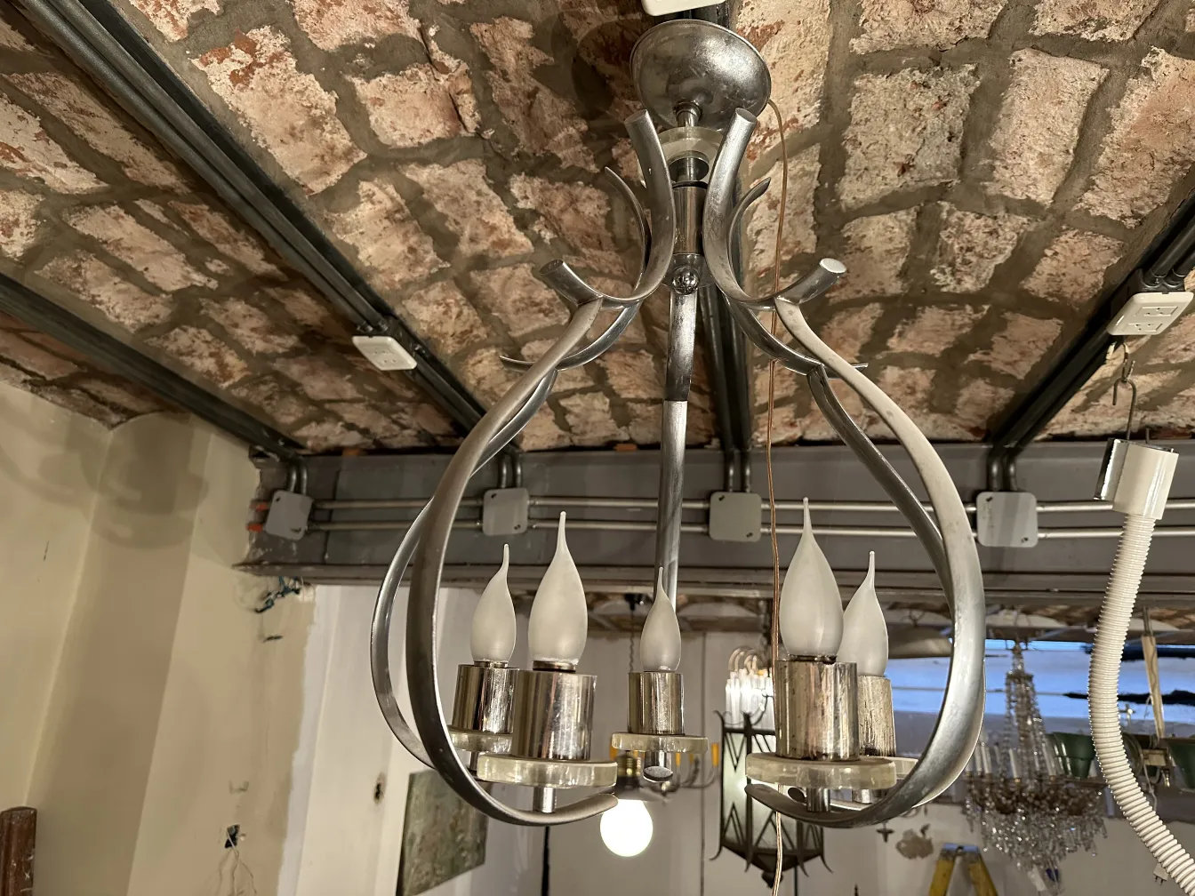 Lustre ancien avec lumières en forme de bougie dans un cadre rustique