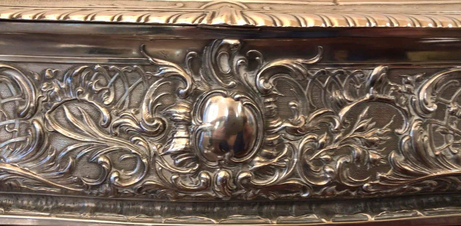 Caixa antiga com decorações intrincadas na superfície.