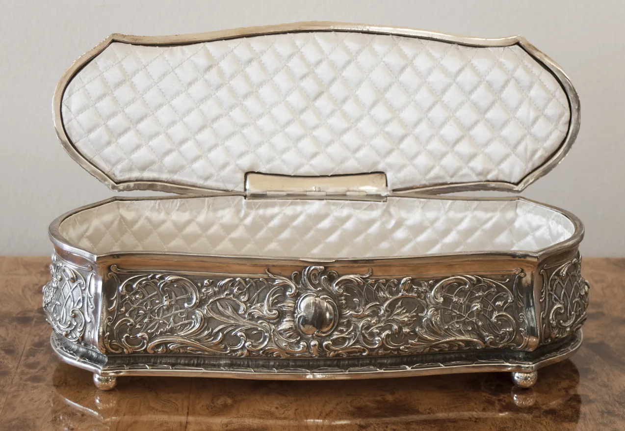 Antique box with intricate details and soft interior.