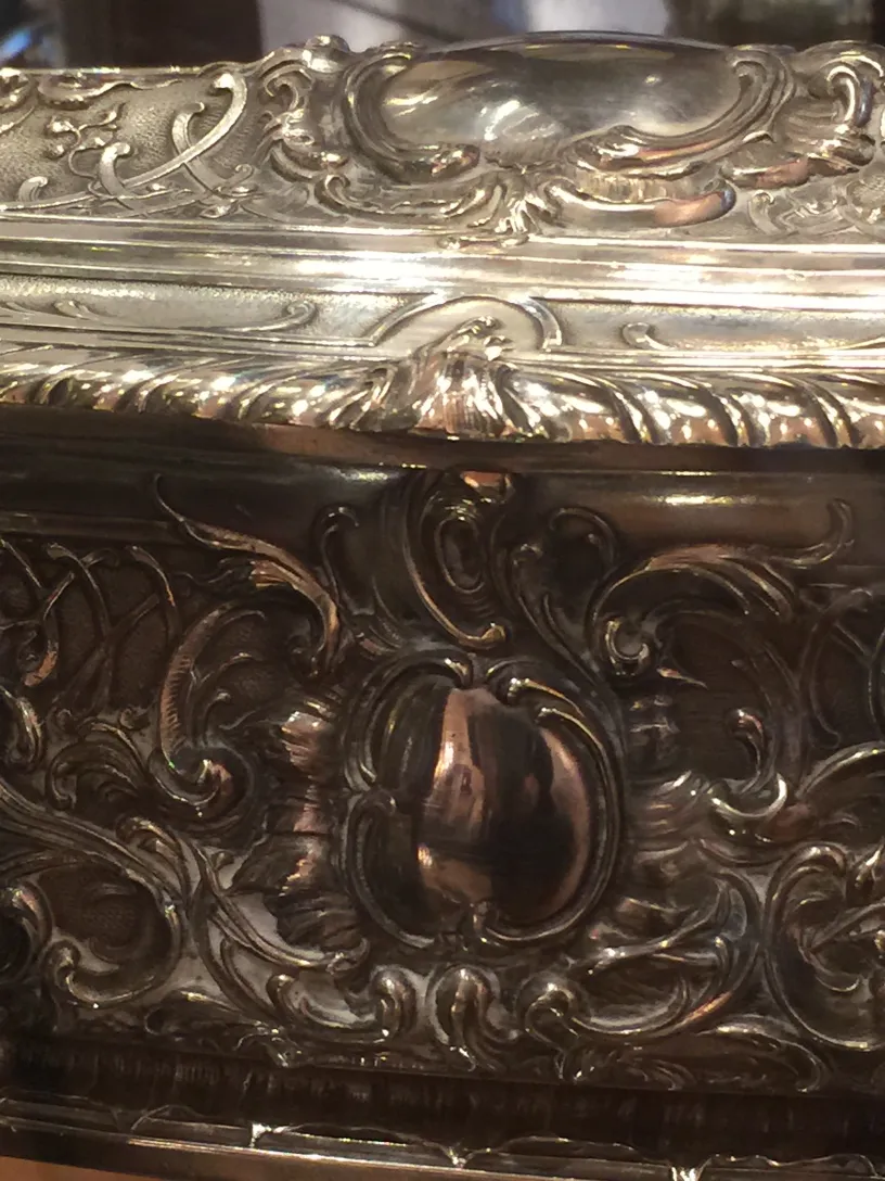 Caixa antiga com padrões decorativos intrincados.