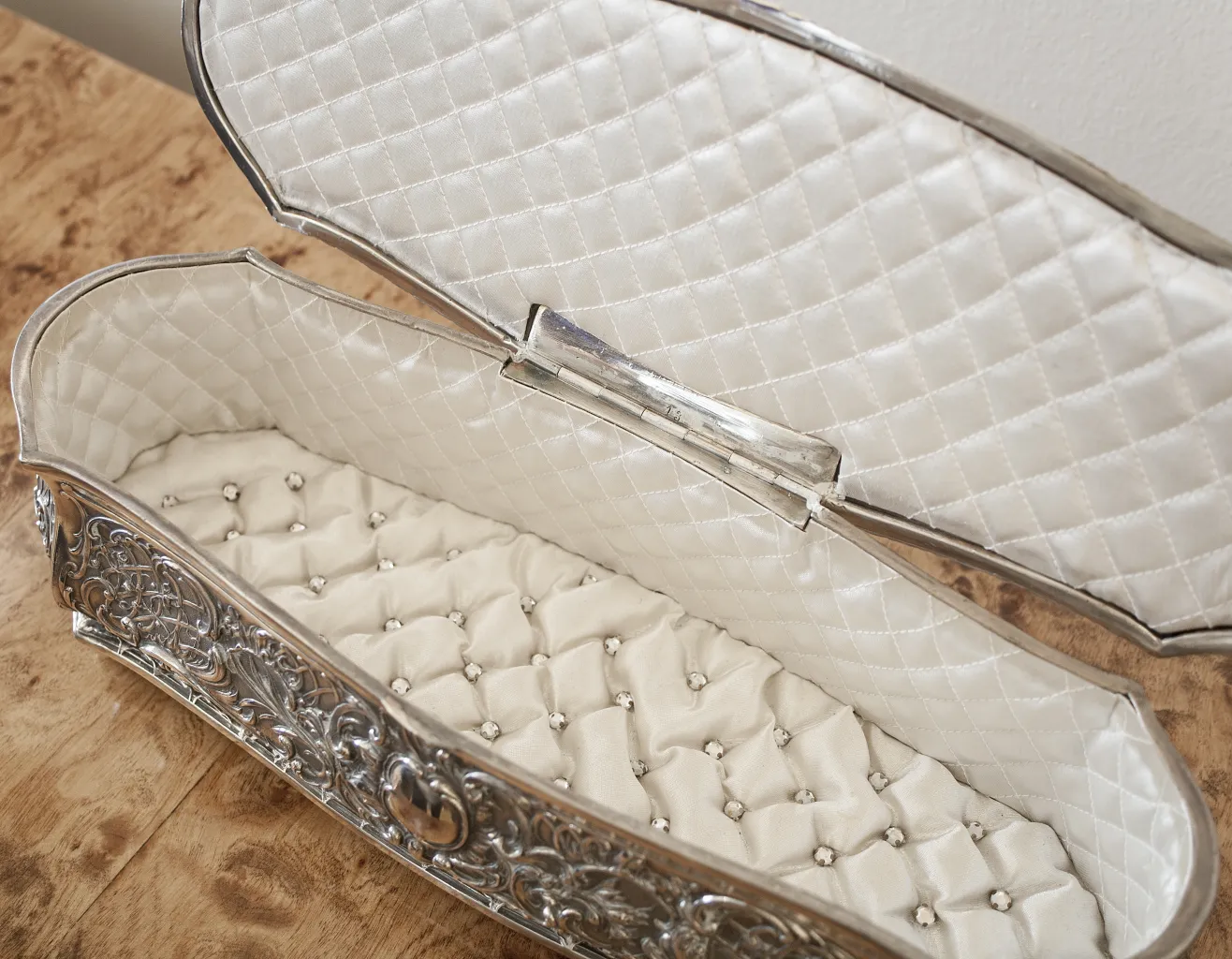 Antique box with elegant decorations and cushioned interior.