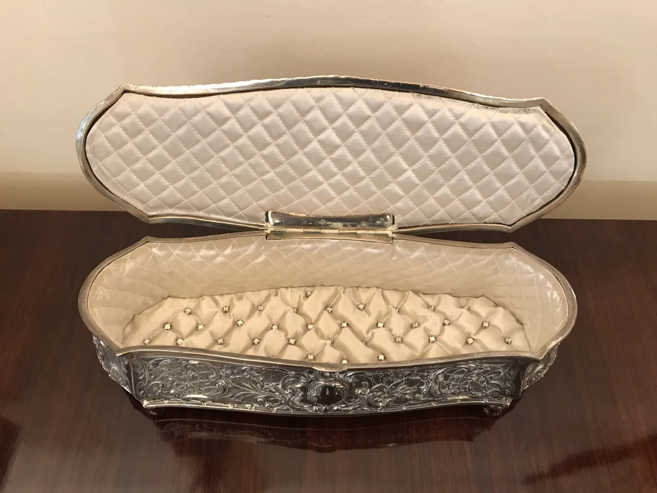 Closed antique box with decorative design and soft interior.
