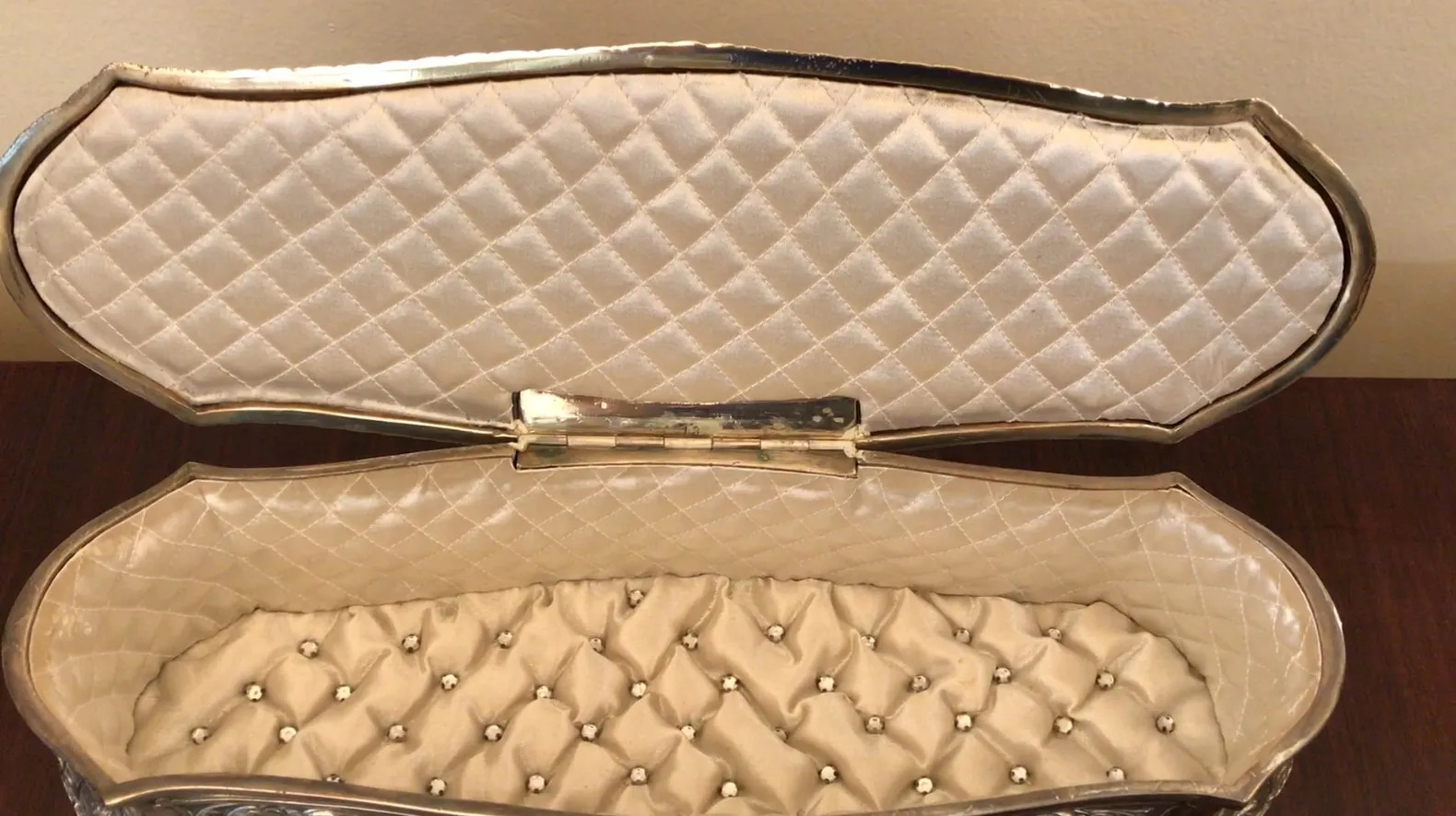 Boîte ancienne de bijoux avec un design élégant et un intérieur doux.