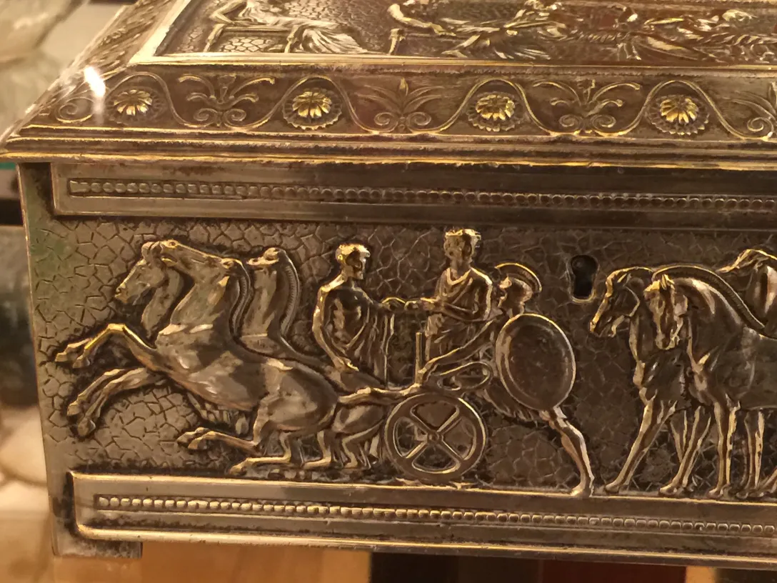 Scatola antica decorata con scene mitologiche e cavalli.