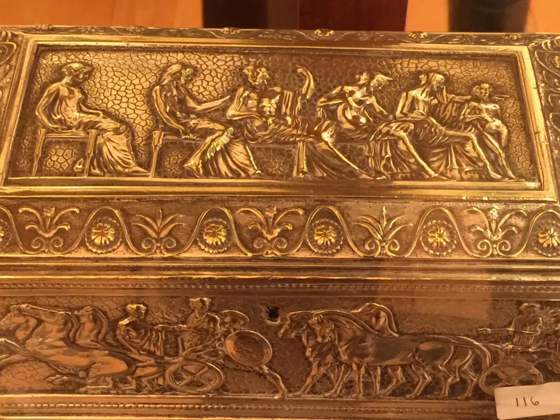 Boîte ancienne avec des reliefs artistiques sur sa surface.