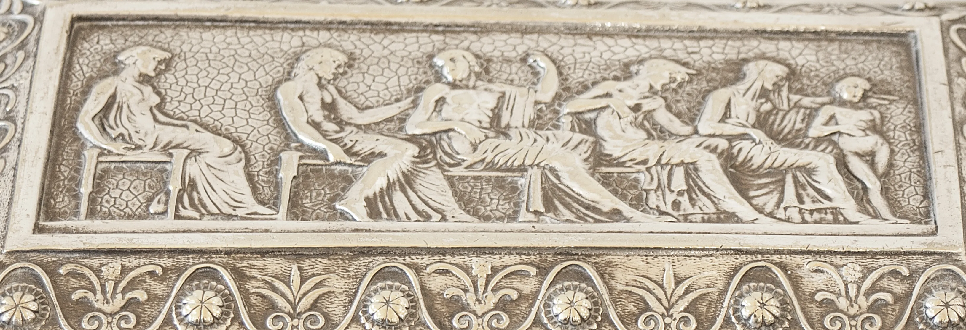 Antike Kiste mit Relief von menschlichen Figuren auf dem Deckel.