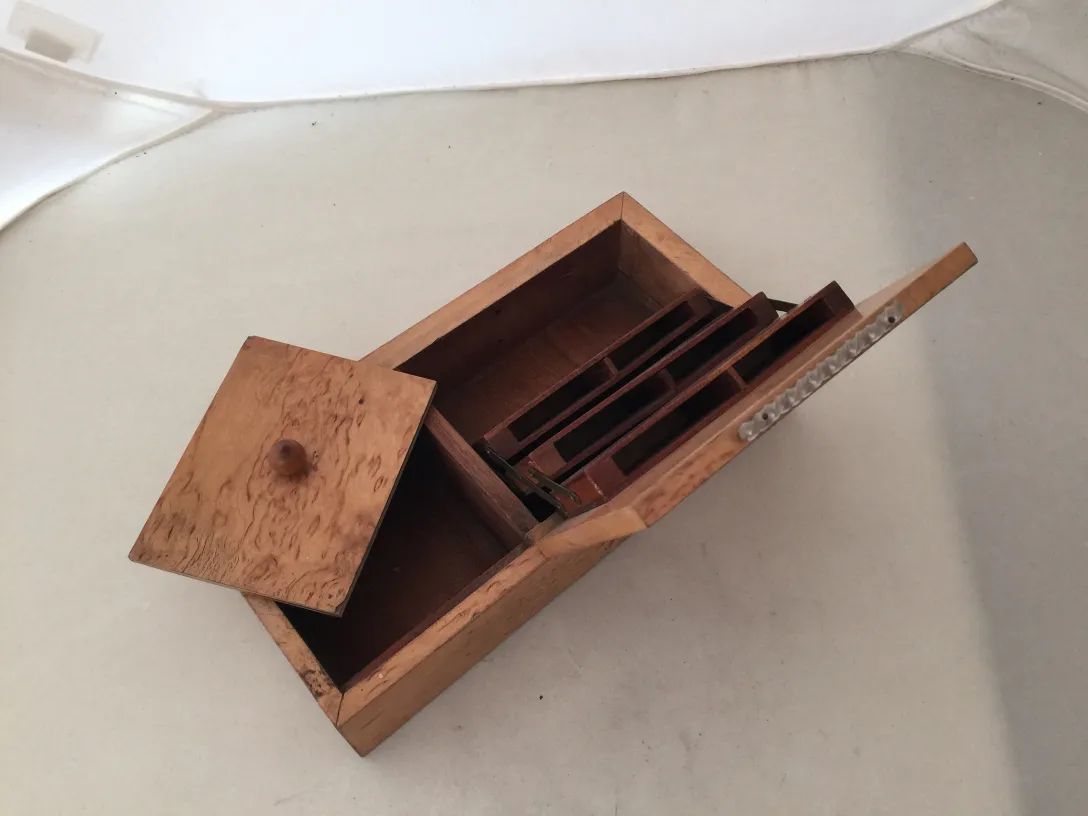 Caja antigua de madera con compartimentos internos.