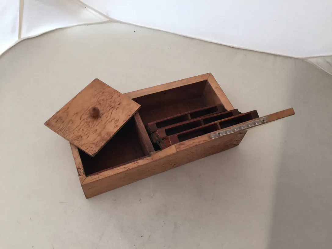 Caja antigua de madera con tapa y compartimentos internos.