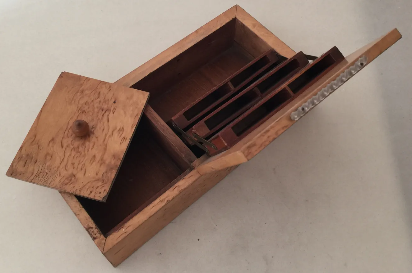 Caja antigua de madera con varios compartimentos.