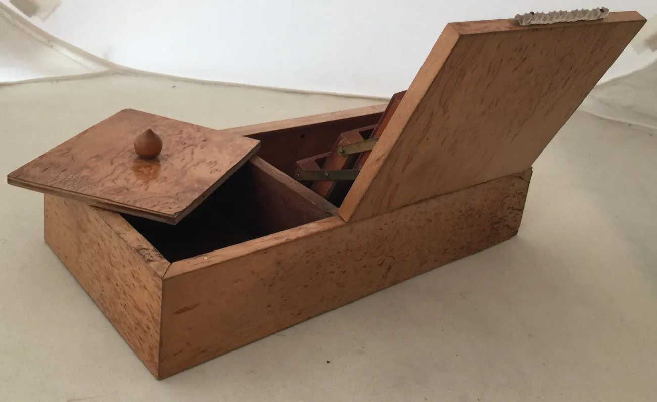 Antique wooden box with lid and details inside.