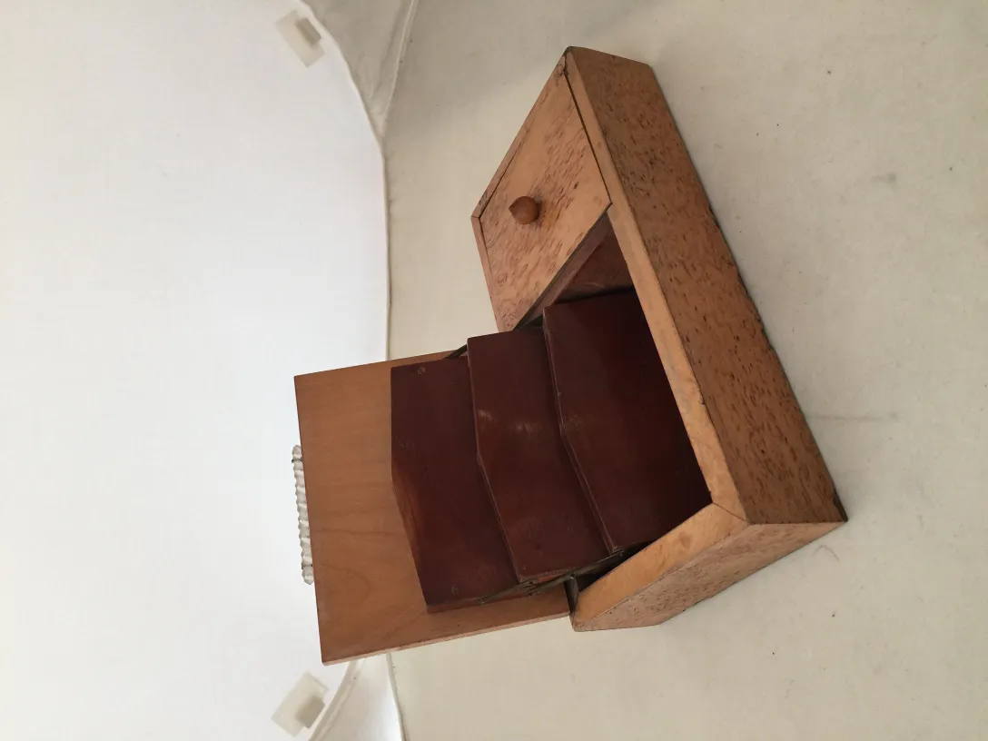 Boîte ancienne en bois avec deux compartiments et un petit tiroir sur fond clair.