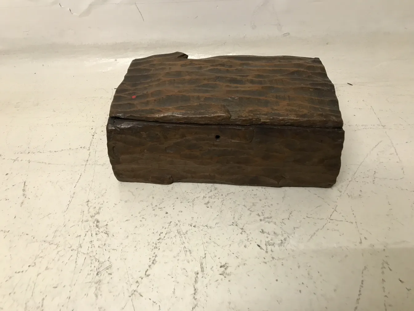 Caja antigua de madera con textura única, fondo neutro.