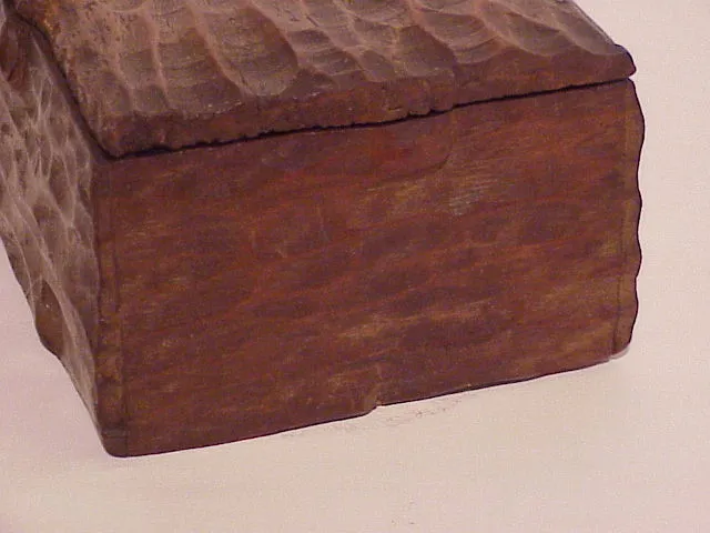 Caixa antiga de madeira com textura única e superfície rústica.