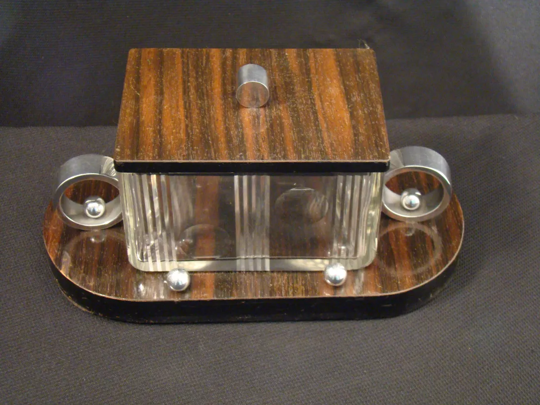 Boîte ancienne translucide avec couvercle et détails métalliques.