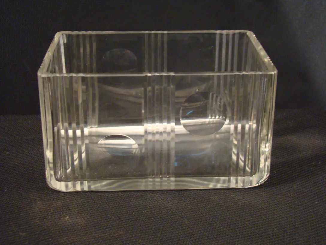 Boîte antique en verre transparent avec des lignes verticales et des cercles.