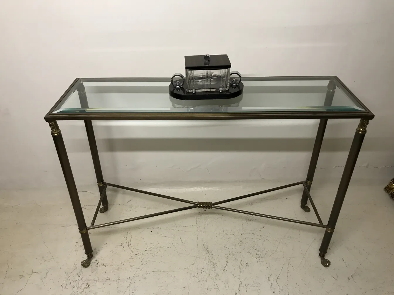 Caixa antiga decorativa sobre uma mesa com tampo de vidro.