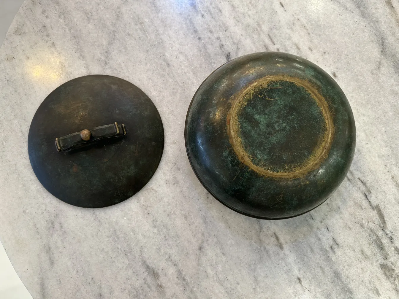 Boîte ancienne avec un couvercle rond et un design unique.