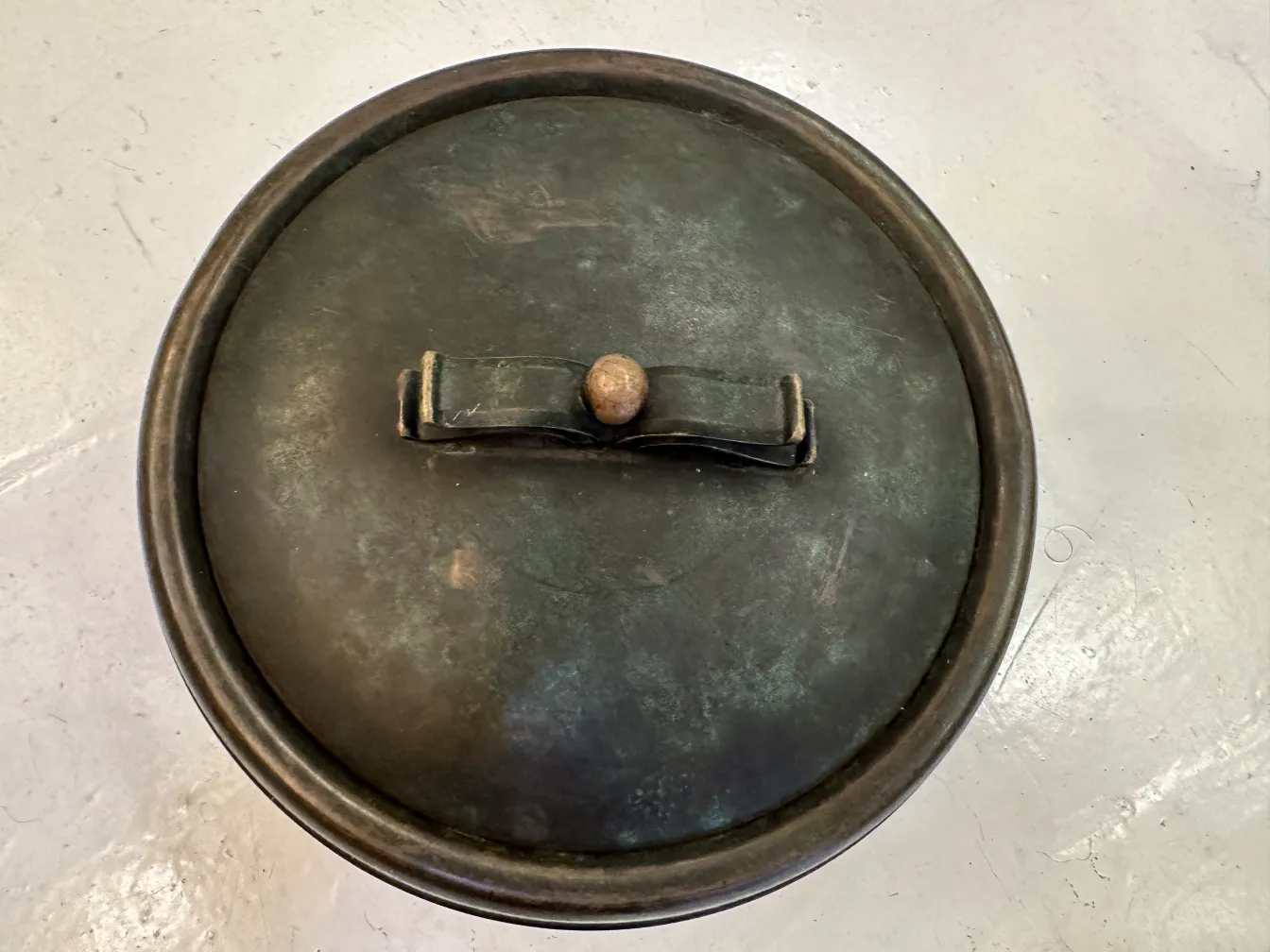 Boîte ancienne avec couvercle et mécanisme de verrouillage visible.