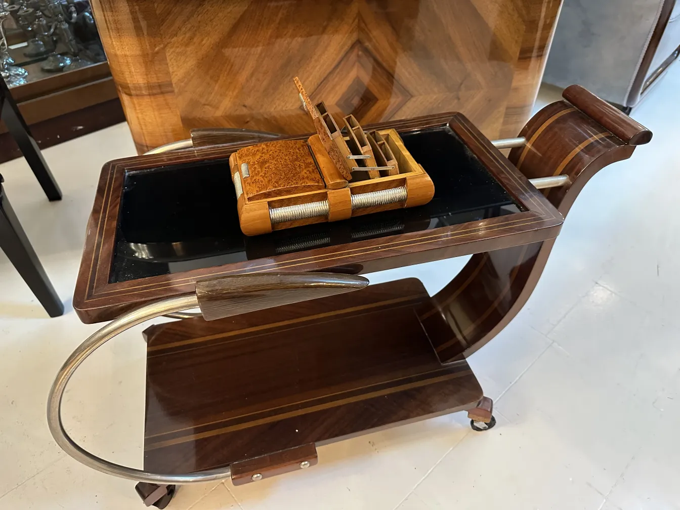 Caja antigua sobre un carro con un acabado elegante.