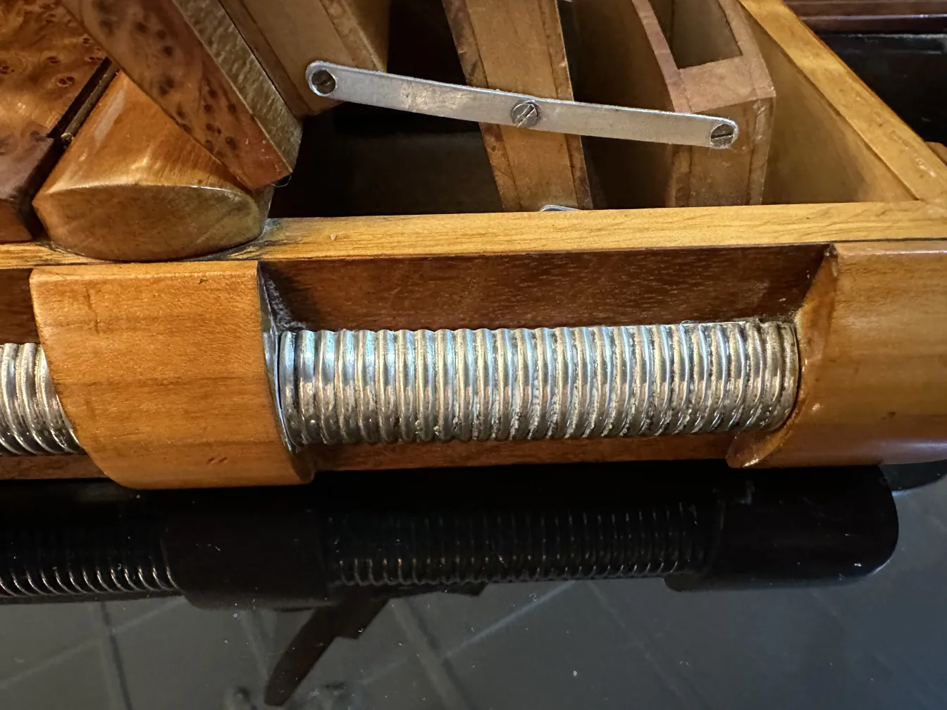 Scatola antica in legno con dettagli in metallo e divisori.