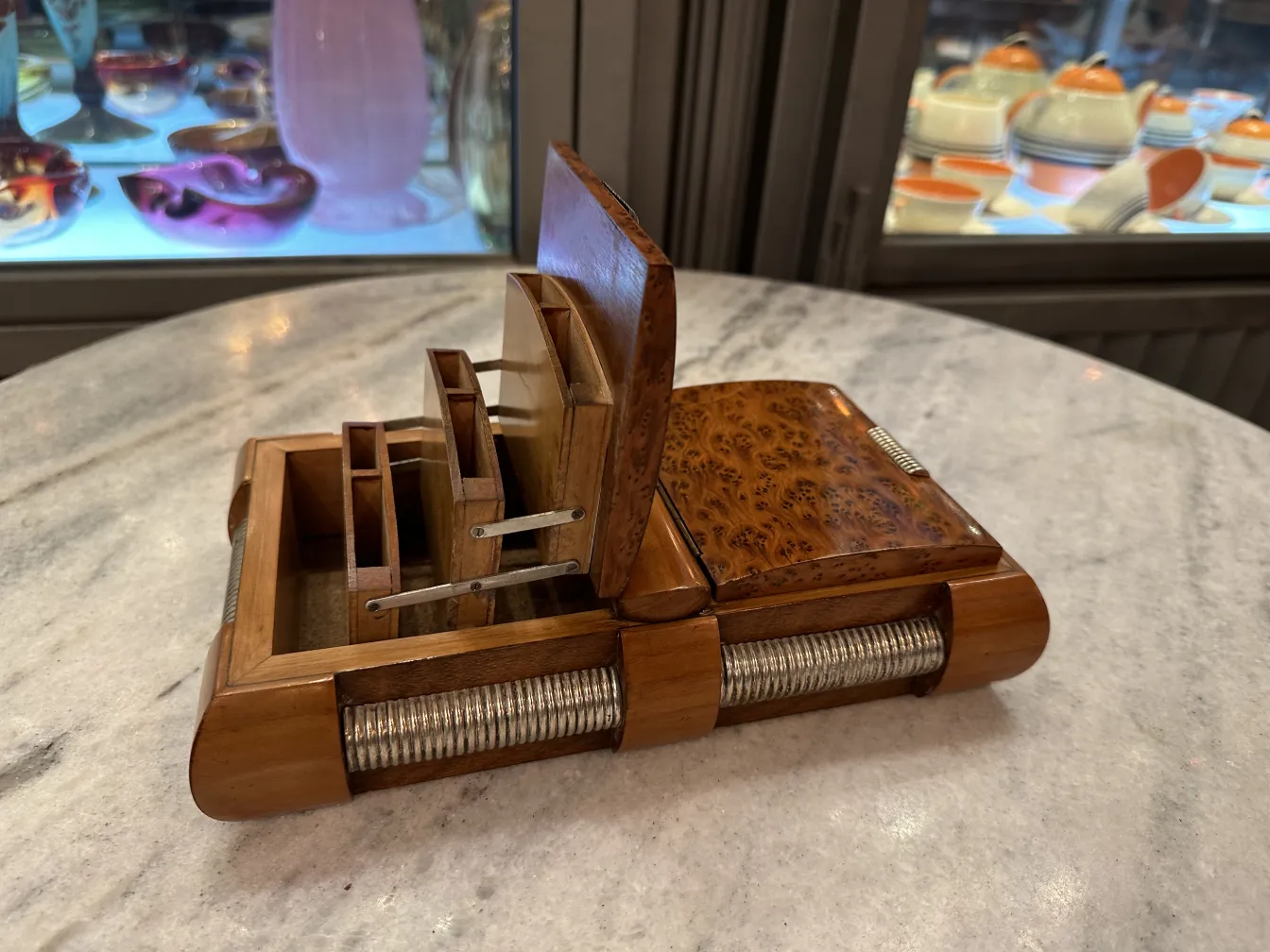 Scatola antica in legno con scomparti e dettagli decorativi, esposta in un ambiente elegante.