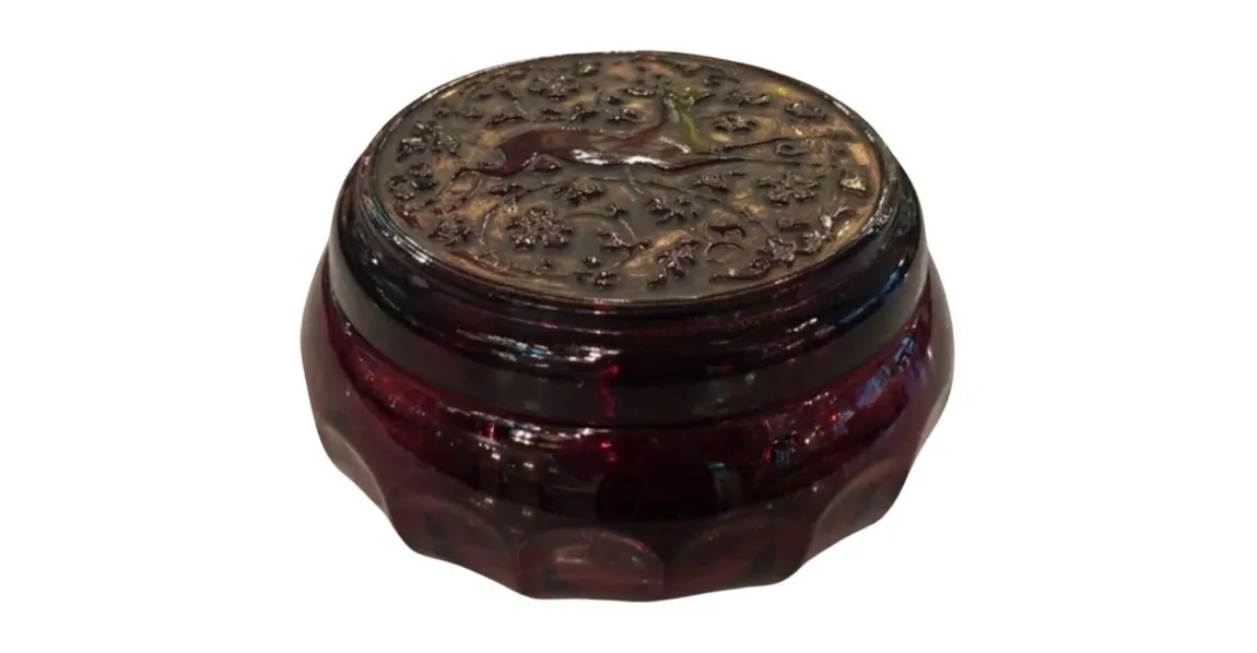 Scatola antica decorata con motivi floreali sul coperchio.