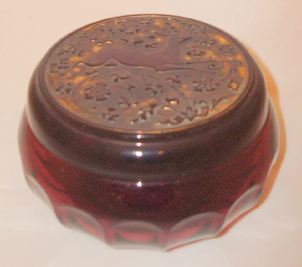 Caja antigua con tapa decorativa en color rojo oscuro, detalles elaborados.