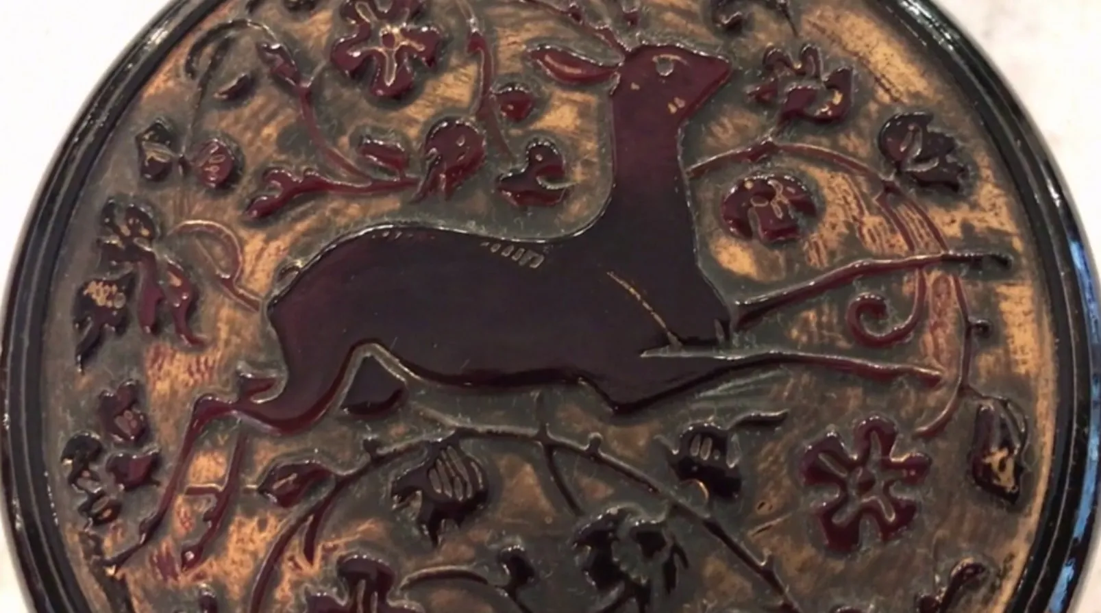 Boîte ancienne avec un cerf en relief et des motifs floraux