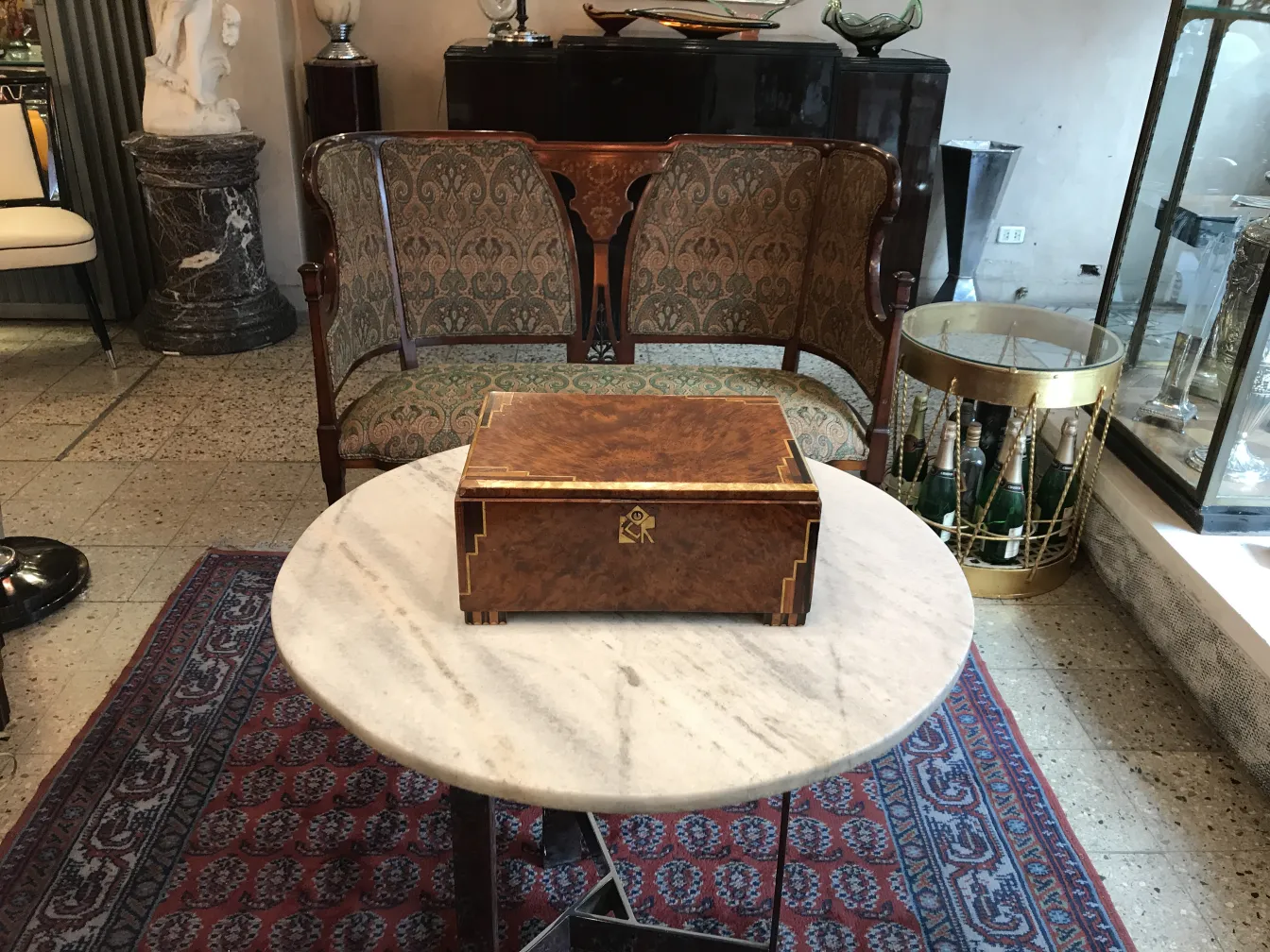 Scatola di legno antica con decorazione sul coperchio, su un tavolo in marmo.