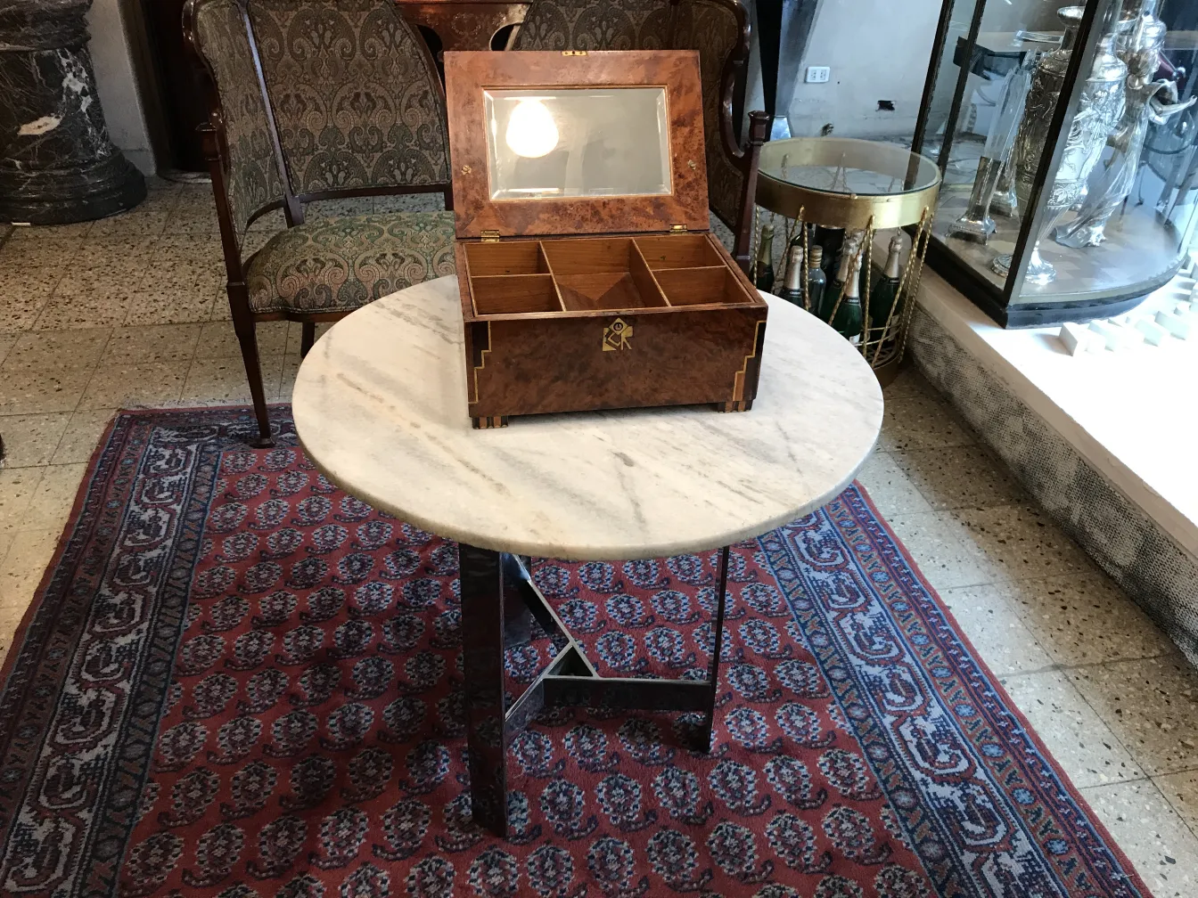 Antique box with a mirror on the lid, placed on a table.