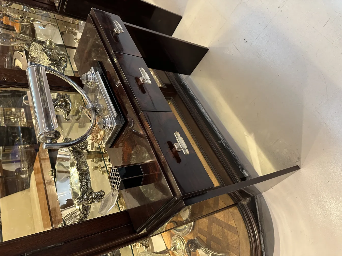 caixa antiga com detalhes visíveis e compartimentos, cercada por antiguidades