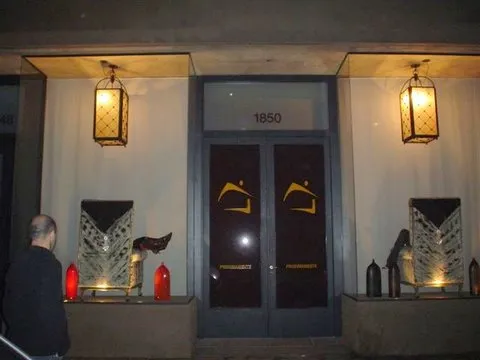 Dois faróis antigos iluminam a entrada, cercados por elementos decorativos.