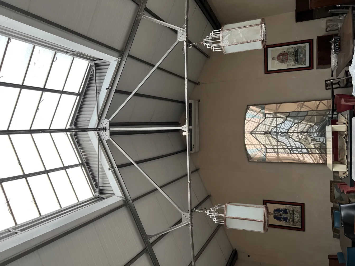 Two antique lanterns hanging in a spacious modern environment.