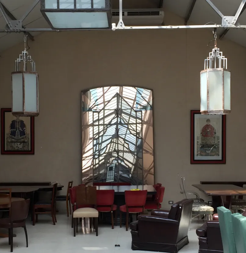 Two antique lanterns hanging in an elegant setting with assorted furniture.