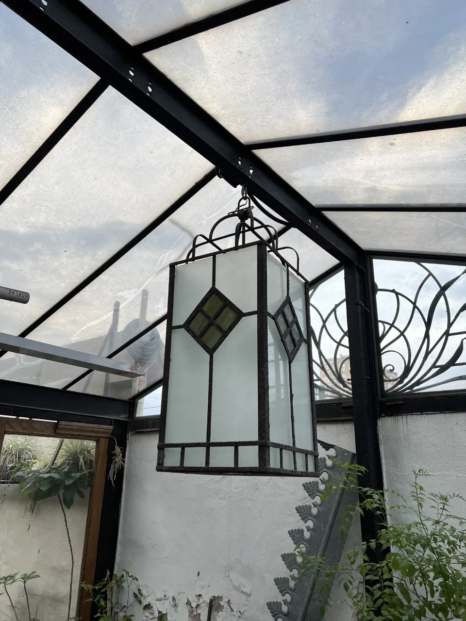 two antique hanging glass lanterns in a bright setting